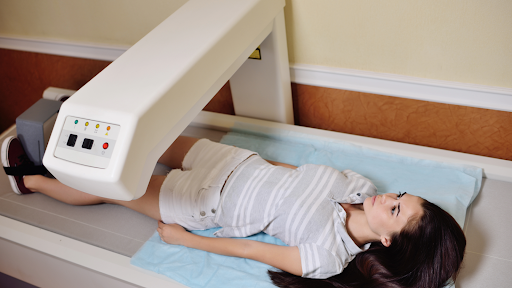 Woman undergoing DEXA scan body composition test at a wellness clinic